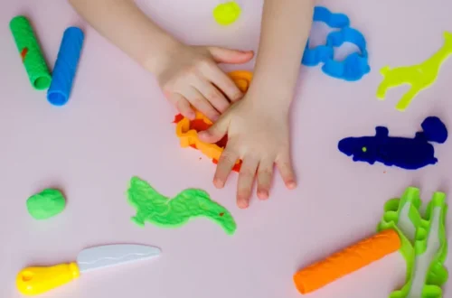 child hands playing colorful clay