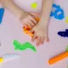 child hands playing colorful clay
